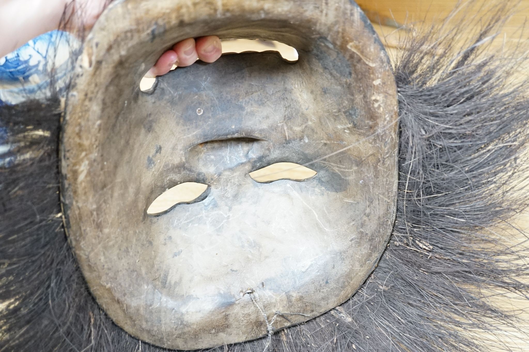 Two Japanese carved wood masks, an African beaded mask and three similar rattles